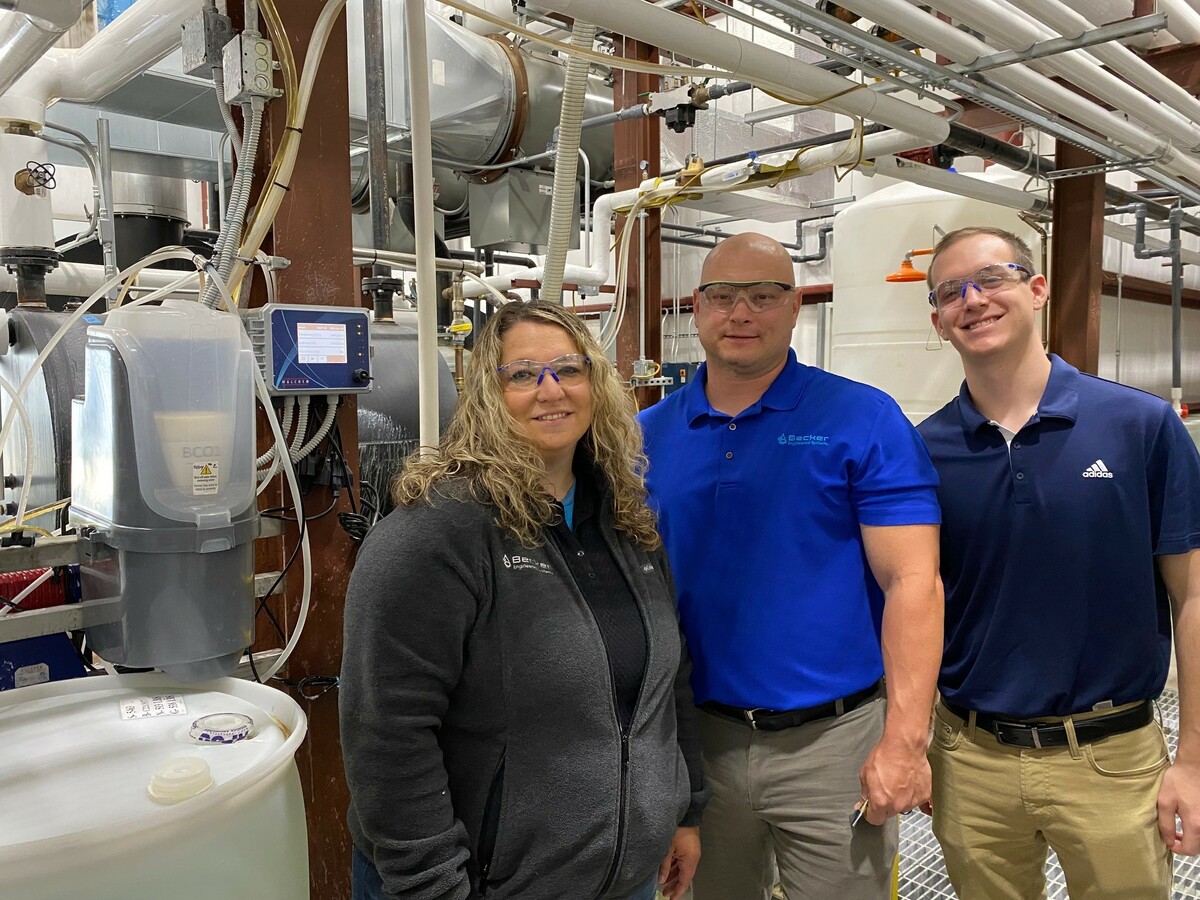 Three people standing in an industrial space